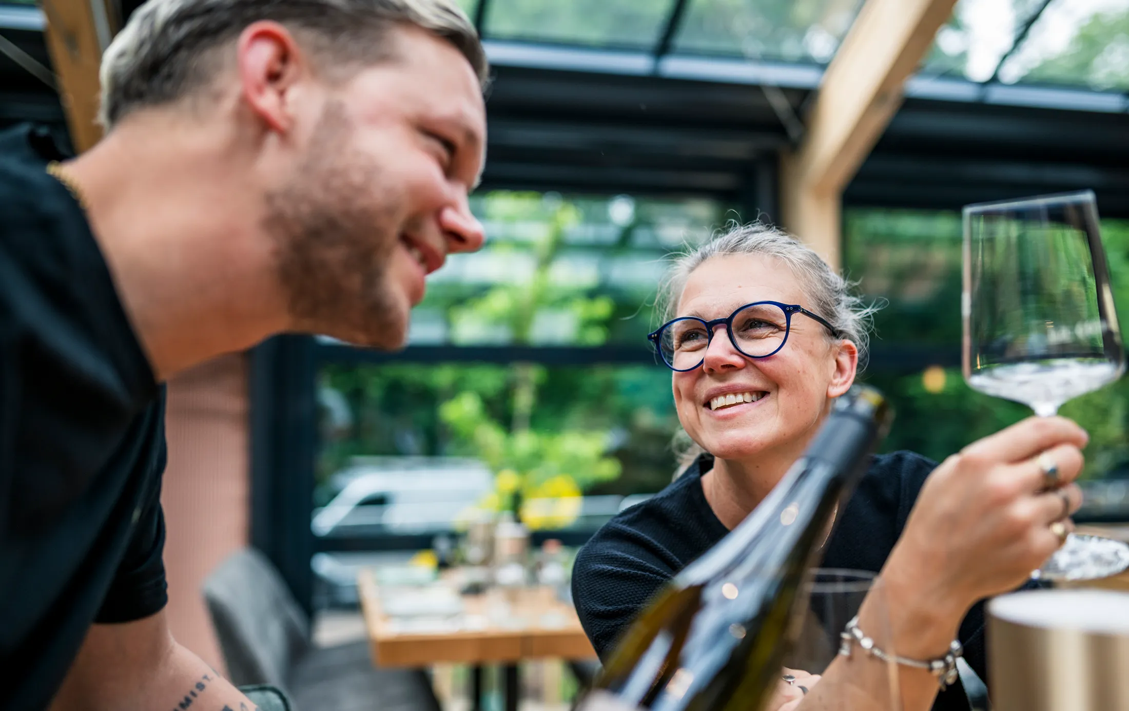 Zwei Personen, die einen Weißwein trinken und sich die Flasche ansehen