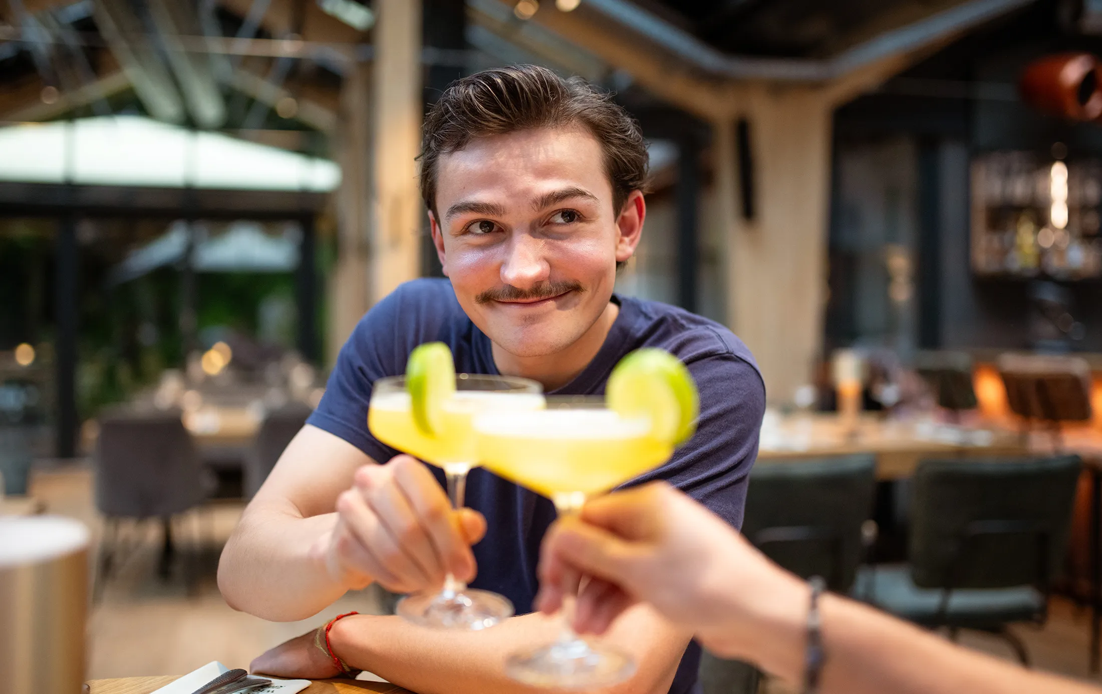 Ein Kunde im Gasthaus mit einem Cocktail in der Hand