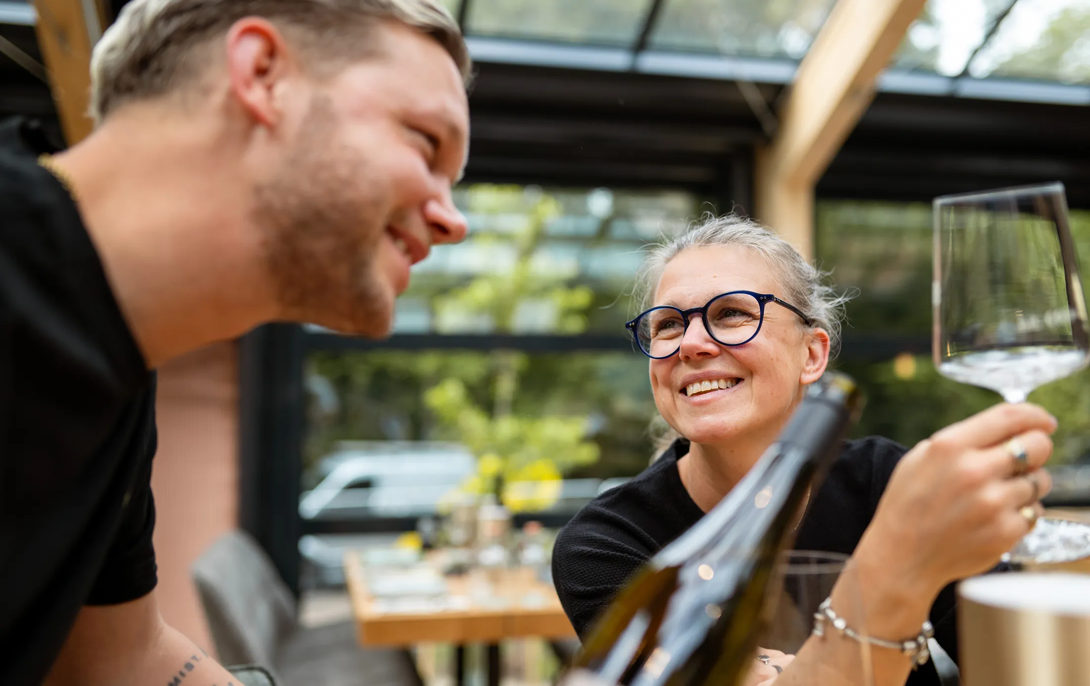 Zwei Personen, die einen Weißwein trinken und sich die Flasche ansehen